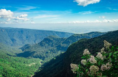 Akşamüstü yeşil ormanlarla kaplı dağ sıraları ve açık mavi gökyüzü düz açılı görüntüler yedi kardeş şelale Cherrapunji meghalaya Hindistan 'da çekildi..