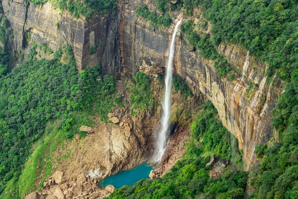 waterfall streams falling from mountain top covered with green forests at day image is taken at Nohkalikai Falls cherrapunji meghalaya india. it is the tallest plunge waterfall in India