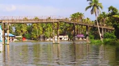 Geleneksel ahşap köprü ve deniz kenarındaki beyaz kilise Alappuzha ya da Alleppey kerala Hindistan 'da çekilen video..