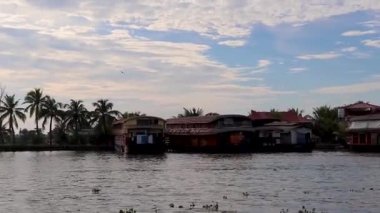 Alappuzha ya da Alleppey kerala Hindistan 'da sabah çekilen inanılmaz gökyüzü ile deniz kenarı kıyılarına demir atmış yüzen evler..