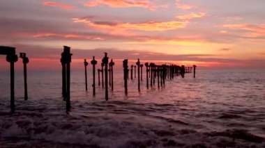 Akşam Alappuzha ya da Alleppey sahilindeki Kerala Hindistan 'da çekilen videoda deniz ufkuna giden demir havuzu olan günbatımı renkli dramatik gökyüzü..