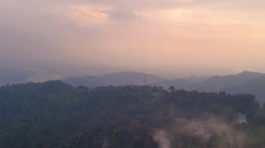 Ormanlarla kaplı dağ sıraları ve sabahları dramatik bulutlu gökyüzü