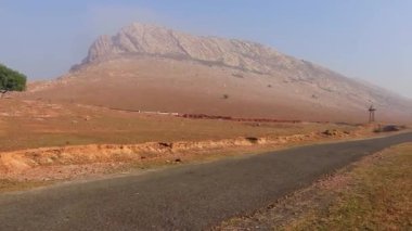 Dağlık ve düz gökyüzü ile ıssız kırsal alanda asfalt yol
