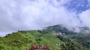 Dağın eteklerinde şehir kurulmuş ve sabah bulutlu gökyüzü