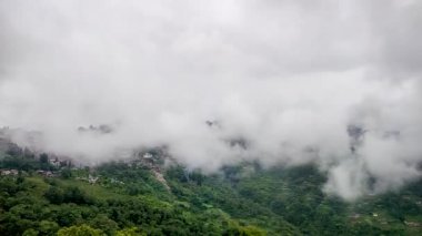 Şehir, sabah düz açıyla hareket eden hızlı beyaz bulutlarla dolu bir dağ sırasına yerleşmiş.