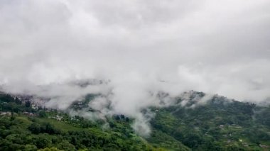 Şehir, sabah düz açıyla hareket eden hızlı beyaz bulutlarla dolu bir dağ sırasına yerleşmiş.