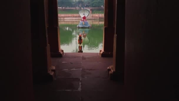 2020年2月11日インドのマハーボディ寺院で撮影された平角ビデオからの朝の水の反射と湖の中央に白い仏像 — ストック動画