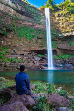 Şelaledeki genç adam dağların tepesinden akarken farklı perspektiften yansıyan görüntüyle Phe Fall Meghalaya Hindistan 'a düştü. Meghalaya 'nın en yüksek şelalelerinden biridir..