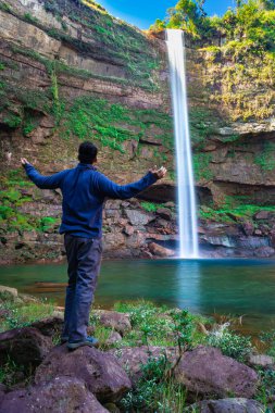 Şelaledeki genç adam dağların tepesinden akarken farklı perspektiften yansıyan görüntüyle Phe Fall Meghalaya Hindistan 'a düştü. Meghalaya 'nın en yüksek şelalelerinden biridir..