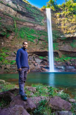 Şelaledeki genç adam dağların tepesinden akarken farklı perspektiften yansıyan görüntüyle Phe Fall Meghalaya Hindistan 'a düştü. Meghalaya 'nın en yüksek şelalelerinden biridir..