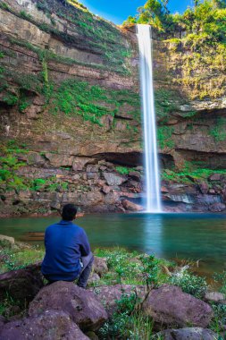 Şelaledeki genç adam dağların tepesinden akarken farklı perspektiften yansıyan görüntüyle Phe Fall Meghalaya Hindistan 'a düştü. Meghalaya 'nın en yüksek şelalelerinden biridir..