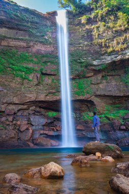 Şelaledeki genç adam dağların tepesinden akarken farklı perspektiften yansıyan görüntüyle Phe Fall Meghalaya Hindistan 'a düştü. Meghalaya 'nın en yüksek şelalelerinden biridir..