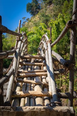 Mawryngkhang trek meghalaya Hindistan 'da sabah ormandaki nehri geçmek için geleneksel bambu köprüsünden düz açı görüntüsü alınır..