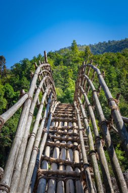 Mawryngkhang trek meghalaya Hindistan 'da sabah ormandaki nehri geçmek için geleneksel bambu köprüsünden düz açı görüntüsü alınır..