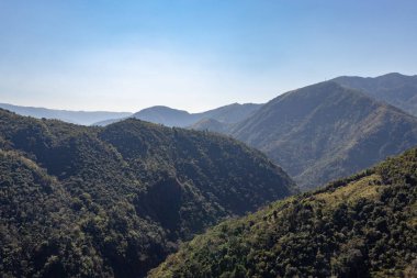 Mawryngkhang trek meghalaya Hindistan 'da sabah yeşil ormanlarla kaplı dağ sıraları ve düz açılı mavi gökyüzü görüntüsü alınır..