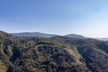 Mawryngkhang trek meghalaya Hindistan 'da sabah yeşil ormanlarla kaplı dağ sıraları ve düz açılı mavi gökyüzü görüntüsü alınır..