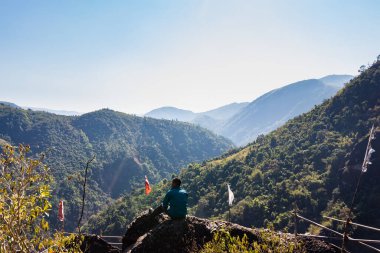Yeşil ormanları ve sisli mavi gökyüzü ile dağların tepesindeki izole genç adam düz açıdan Mawryngkhang trek meghalaya Hindistan 'da çekilmiştir..
