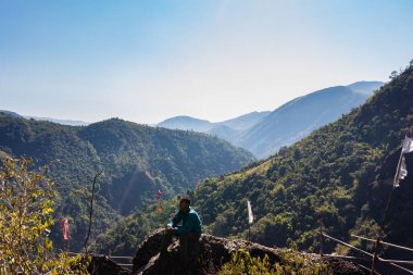 Yeşil ormanları ve sisli mavi gökyüzü ile dağların tepesindeki izole genç adam düz açıdan Mawryngkhang trek meghalaya Hindistan 'da çekilmiştir..
