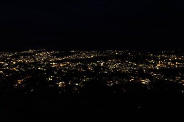 Şehir merkezi gece görüşü. Dağların tepesinden gelen koyu siyah arkaplanlı ışıklandırma akşam üstü Hindistan 'da çekiliyor..