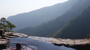 Adam dağ yamacında doğal yüzme havuzunda yüzüyor. Üst açılardan. Nungnah meghalaya Hindistan 'da çekilmiş bir video..