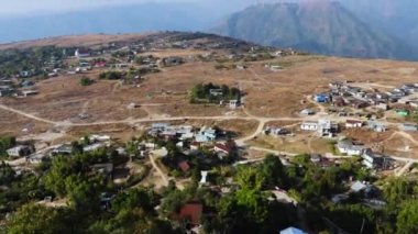 Nungnah meghalaya Hindistan 'da çekilen yüksek açılı videodan sabah parlak gökyüzü olan dağın tepesindeki küçük uzak bir köy..