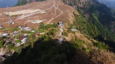 Nungnah meghalaya Hindistan 'da çekilen yüksek açılı videodan sabah parlak gökyüzü olan dağın tepesindeki küçük uzak bir köy..
