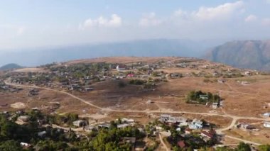 Nungnah meghalaya Hindistan 'da çekilen yüksek açılı videodan sabah parlak gökyüzü olan dağın tepesindeki küçük uzak bir köy..