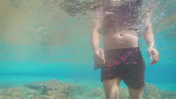 Młody Człowiek Spacerujący Błękicie Jasne Pod Wodą Wodospadu Wielu Skał — Wideo stockowe