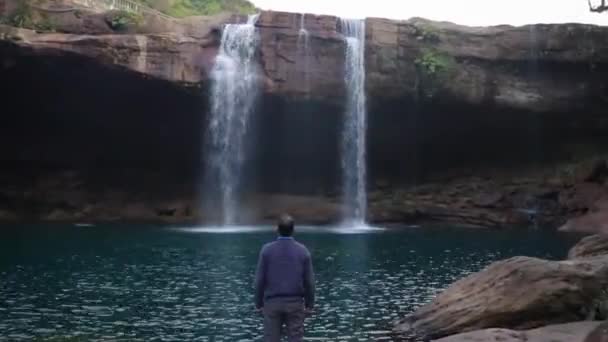 Ung Man Njuter Det Naturliga Vattenfallet Faller Från Bergstoppen Morgonen — Stockvideo