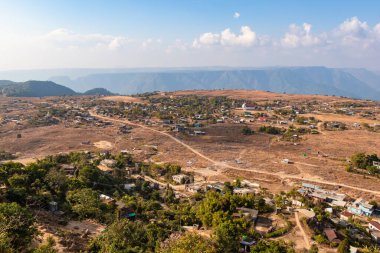 Nungnah meghalaya Hindistan 'da çekilen yüksek açılı görüntüden sabah parlak gökyüzü ile dağın tepesindeki küçük uzak bir köy..