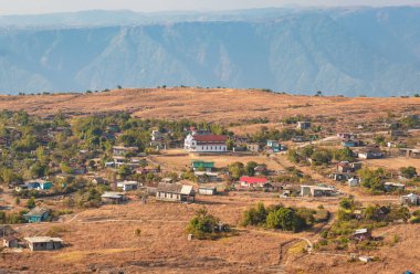 Nungnah meghalaya Hindistan 'da çekilen yüksek açılı görüntüden sabah düz gökyüzü ile dağın tepesindeki küçük uzak bir köy..