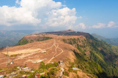 Nungnah meghalaya Hindistan 'da çekilen yüksek açılı görüntüden sabah parlak gökyüzü ile dağın tepesindeki küçük uzak bir köy..
