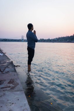 Nehir kıyısındaki kutsal Ganj Nehri 'ni tarayan izole genç adam Ganga Nehri kıyısı Rishikesh uttrakhand Hindistan' da çekildi..