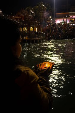 Ganga nehri kıyısındaki kutsal ganges nehrinin düz açılı görüntüsünü çeken izole genç kız Ganga nehri kıyısı haridwar uttrakhand Hindistan 'da çekildi..
