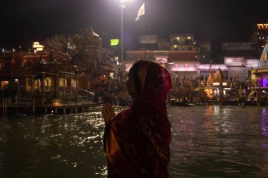 Ganga nehri kıyısındaki kutsal ganges nehrinin düz açılı görüntüsünü çeken münzevi kadın Ganga nehri kıyısı haridwar uttrakhand Hindistan 'da çekildi..