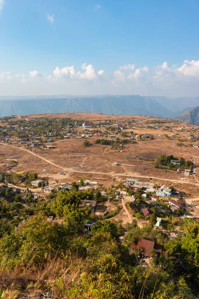 Nungnah meghalaya Hindistan 'da çekilen yüksek açılı görüntüden sabah parlak gökyüzü ile dağın tepesindeki küçük uzak bir köy..