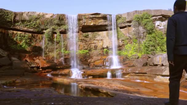 Joven Hombre Disfrutando Prístina Cascada Natural Que Cae Cima Montaña — Vídeo de stock