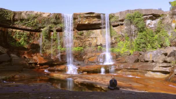 Mladý Muž Medituje Přírodní Vodopád Padající Vrcholu Hory Den Nízkého — Stock video