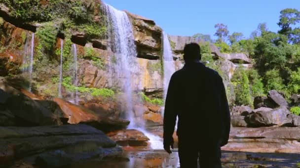 Joven Hombre Disfrutando Prístina Cascada Natural Que Cae Cima Montaña — Vídeo de stock