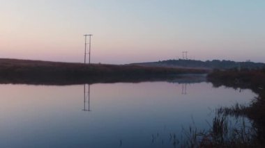 sakin göl suyu yansıması ve gün doğumuyla dramatik turuncu gökyüzü sabah saatinde