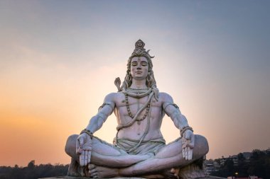 Hindu tanrısı Shiva heykeli, akşamları dramatik gökyüzü ile meditasyon pozisyonunda Parmarth Niketan rishikesh uttrakhand Hindistan 'da çekiliyor..