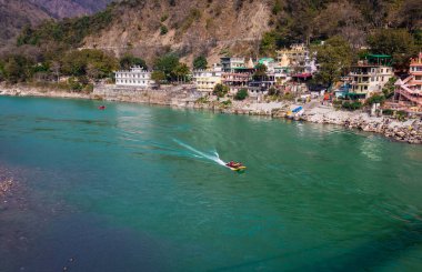 Nehir kenarına kurulmuş şehir ile dağların arasından akan Ganj nehri 15 Mar 2022 'de Rishikesh uttrakhand Hindistan' da çekilir..