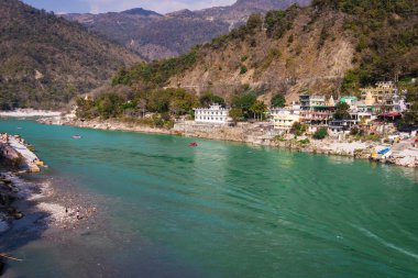 Nehir kenarına kurulmuş şehir ile dağların arasından akan Ganj nehri 15 Mar 2022 'de Rishikesh uttrakhand Hindistan' da çekilir..