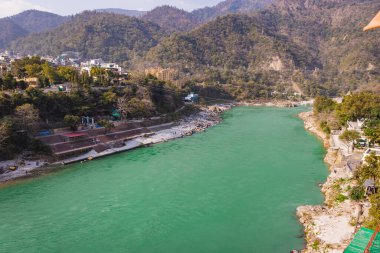 Nehir kenarına kurulmuş şehir ile dağların arasından akan Ganj nehri 15 Mar 2022 'de Rishikesh uttrakhand Hindistan' da çekilir..