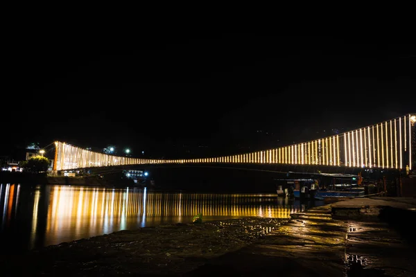 Железный Подвесный Мост Освещается Паром Огни Отражением Воды Разных Углов — стоковое фото