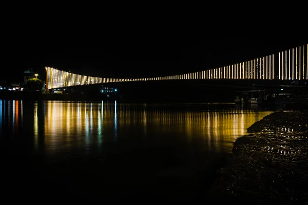 Железный Подвесный Мост Освещается Паром Огни Отражением Воды Разных Углов — стоковое фото