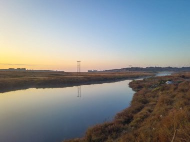 Sakin göl dramatik gündoğumu ile mavi gökyüzü yansıması sabah