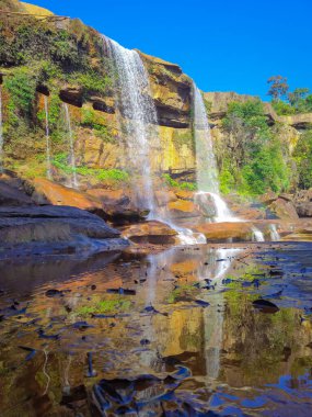 Dağın tepesinden düşen şelale yansıması ve mavi gökyüzü sabah alçak açıyla