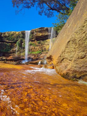 Dağın tepesinden düşen şelale yansıması ve mavi gökyüzü sabah alçak açıyla