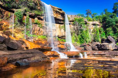Şelale dağın tepesinden düşerken yansıma ve mavi gökyüzü sabah eşsiz bir açıyla